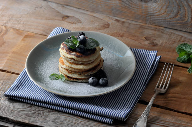 istock Appetizing pancakes are decorated with blueberries, blackberries, mint and sprinkled with powdered sugar. 1155444506
