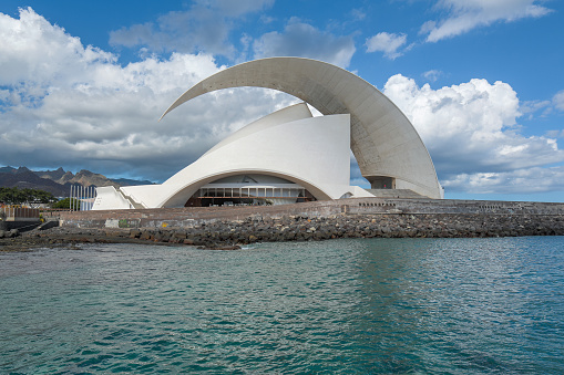 Sunny weather view of the Auditorio de Tenerife Adán Martín with ocean bay blue sky and clouds. building by the architect - Santiago Calatrava.  Santa Cruz de Tenerife, Tenerife, Canary Islands, Spain, October 20, 2018