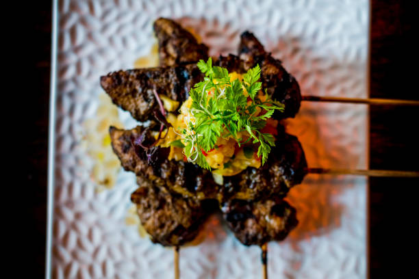 Char-grilled jerk marinated chicken tenders in skewers with fruit salsa on top