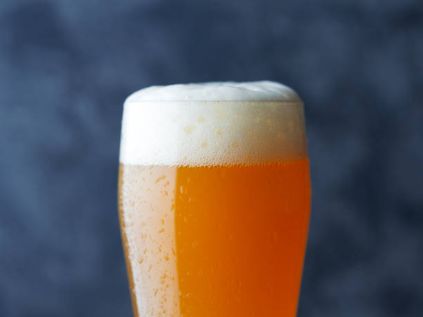 nahaufnahme eines glases kaltem weizen handwerk bier in satte orange farbe - weizenbier stock-fotos und bilder