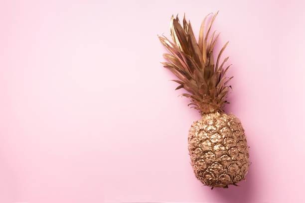istock Creative layout. Gold pineapple on pink background with copy space. Top view. Tropical flat lay. Exotic food concept, crazy trend 1155446138