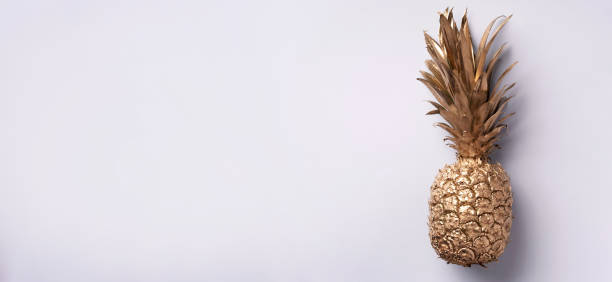 istock Creative layout. Gold pineapple on grey background with copy space. Top view. Tropical flat lay. Exotic food concept, crazy trend. Banner 1155446153