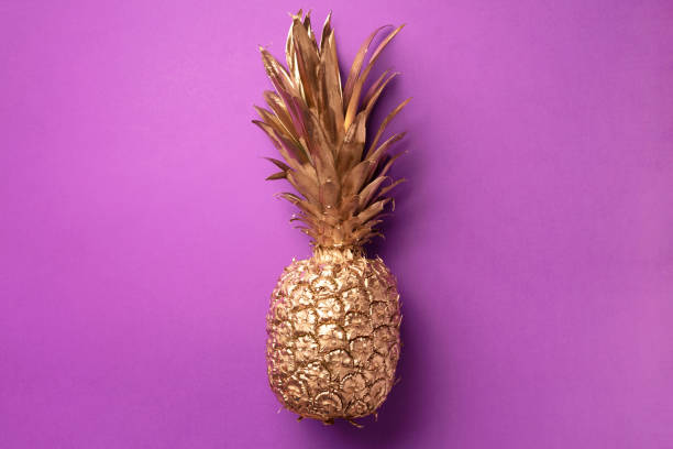 istock Creative layout. Gold pineapple on violet background with copy space. Top view. Tropical flat lay. Exotic food concept, crazy trend. Banner 1155446207