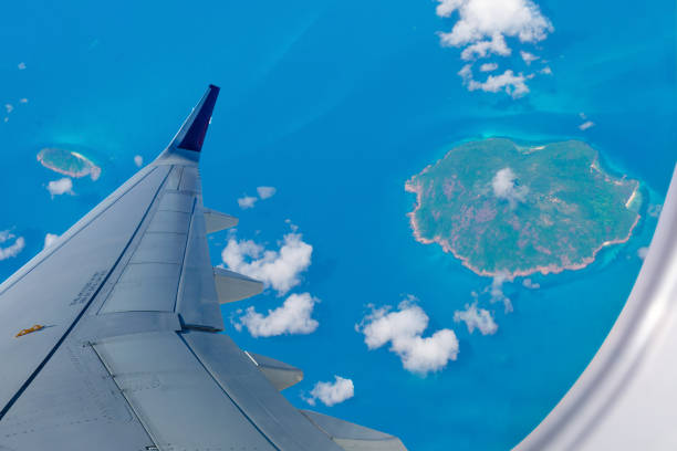 Airplane over Indonesian islands. Island view through aircraft window over the ocean.