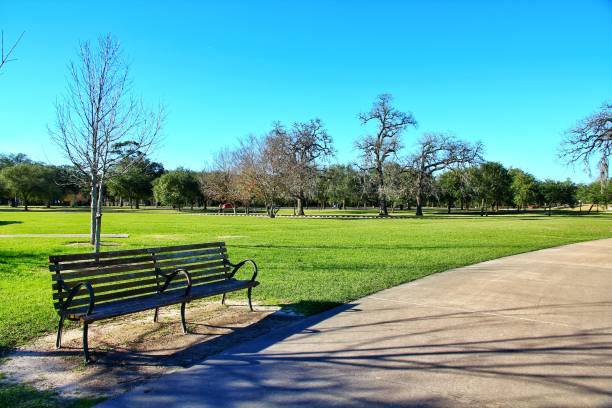 istock Blue sky scenery in Hermann Park landscapes with a bench and a path in a foreground, Houston Texas 1155448186