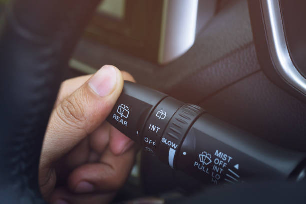 istock close up hand adjusting rain windscreen wiper knob control stick switch speed of screen front car. Adjustable wiper blade remove dirt from the windshield. Modern car interior detail. 1155450281