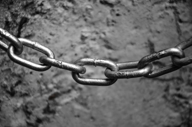 istock chain on the background of the old concrete wall 1155451234