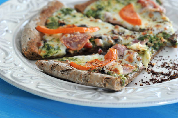 istock A few slices of pizza on a white plate. Clearly visible bacon, spinach, tomatoes, melted cheese. 1155452149