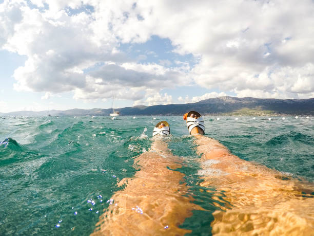 point de vue personnel des pieds de femme portant des sandales nageant dans la mer adriatique à split, croatie - leg split photos et images de collection