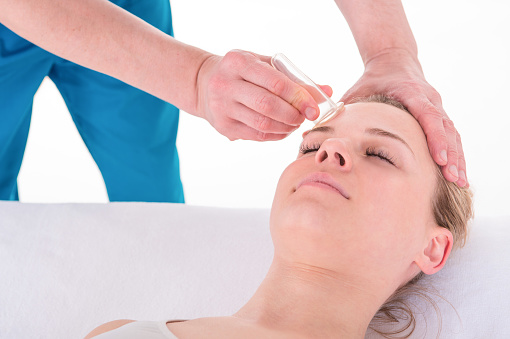 La mujer joven recibe tratamiento facial de masaje de rejuvenecimiento facial en la acupuntura Wellness Spa photo
