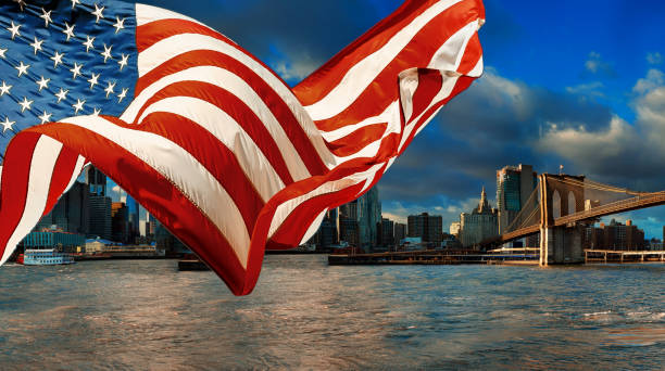 bandera americana volando la vista de skyline de nueva york ciudad de manhattan centro de horizonte - new york city brooklyn new york state bridge fotografías e imágenes de stock