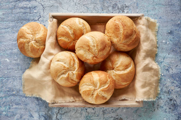 istock Crusty round bread rolls, known as Kaiser or Vienna rolls on linen towel 1155456024