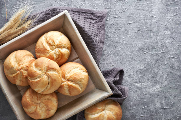 istock Crusty round bread rolls, known as Kaiser or Vienna rolls on linen towel 1155457058