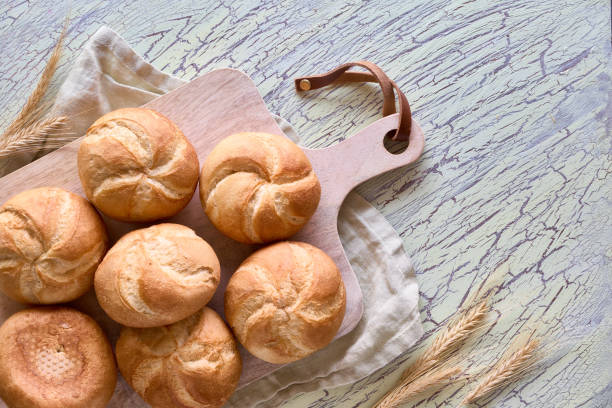istock Crusty round bread rolls, known as Kaiser or Vienna rolls on linen towel 1155458306