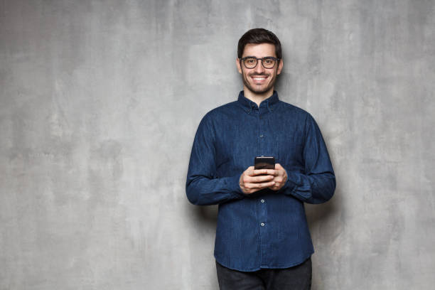 istock European man with telephone in hands isolated on background, copyspace on left 1155458441