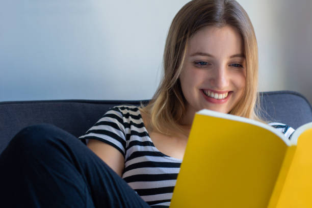 istock Woman reading a book at home 1155459078
