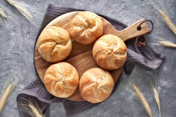 istock Crusty round bread rolls, known as Kaiser or Vienna rolls on linen towel 1155459335