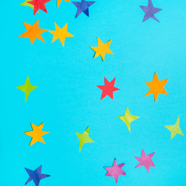 istock stars cut from colored papers on blue paper 1155459613