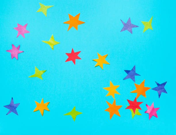istock multicolored stars cut from papers on blue paper 1155459620