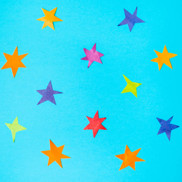 istock various stars cut from colour papers on blue paper 1155459639