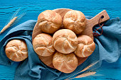 Crusty round bread rolls, known as Kaiser or Vienna rolls on linen towel