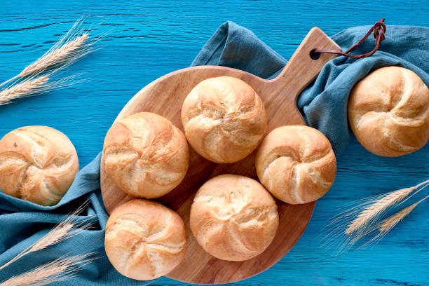 istock Crusty round bread rolls, known as Kaiser or Vienna rolls on linen towel 1155460510