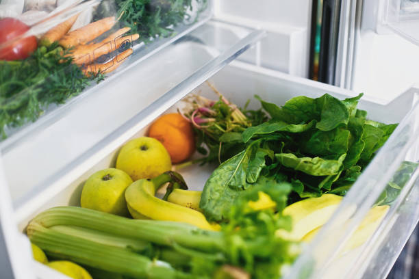 istock Vegetarian diet. Plastic free bananas,salad, spinach, celery, apples, orange in fridge. Zero waste grocery shopping. Fresh vegetables in opened drawer in refrigerator.  Food delivery 1155460742