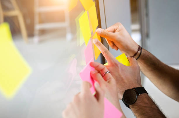 istock Colleagues discussing business ideas on sticky notes 1155460972