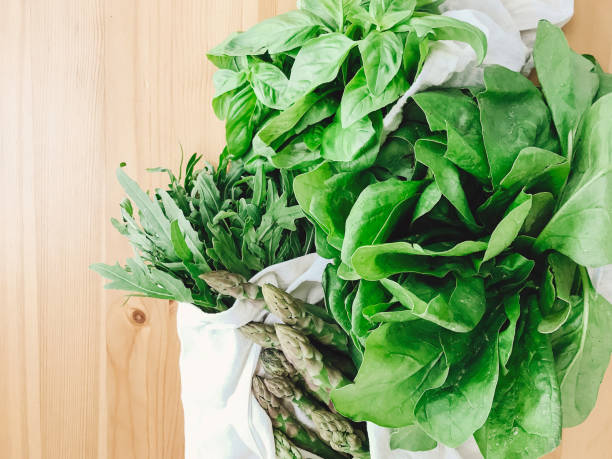 istock Reusable eco friendly bag with fresh asparagus, arugula,spinach on wooden table, top view. Zero waste grocery shopping concept. Ban plastic. Choose plastic free. Organic cotton bags 1155460989