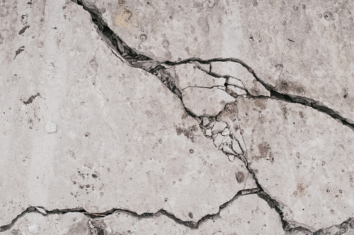 Crack concrete wall. Old dirty cracked wall texture. Gray stone background. Abstract pattern of grunge floor. Messy damage worn of broken building