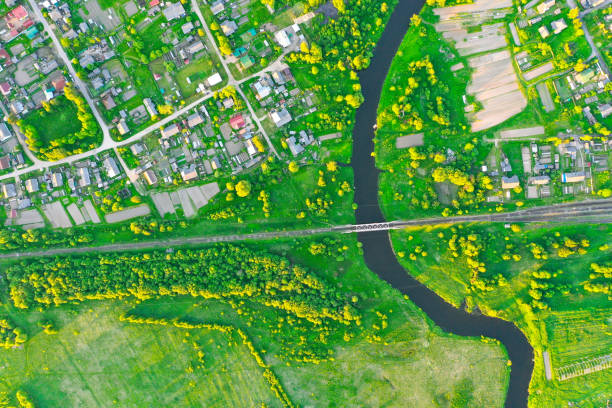 Aerial view landscape of winding small river among the small town, stream in green field, top view meadow. Aerial view landscape of winding small river among the small town, stream in green field, top view meadow topography photos stock pictures, royalty-free photos & images