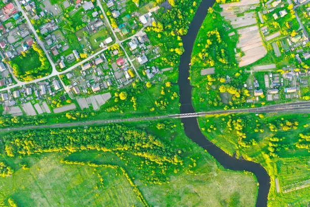 Photo of Aerial view landscape of winding small river among the small town, stream in green field, top view meadow.