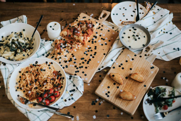 istock Messy dining table with leftover food covered with confetti after party celebration 1155466492