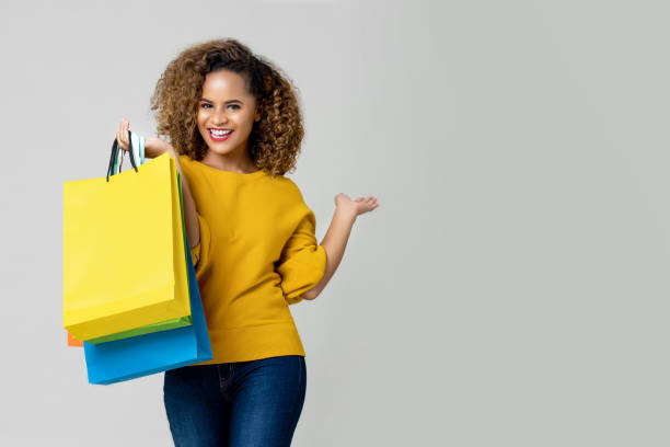 la joven afroamericana está sosteniendo bolsas de compras - shopping bag shopping retail bag fotografías e imágenes de stock