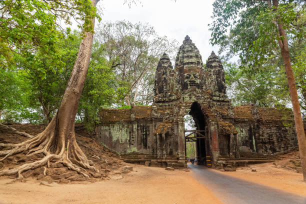 istock small road through a ancient stone gate in the jungle with giant faces in Cambodia 1155467475