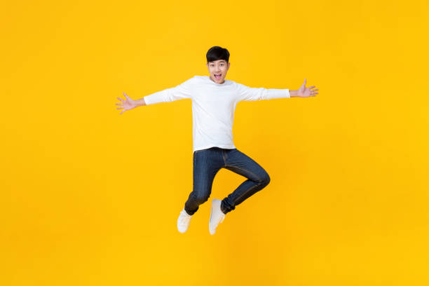 istock Young Asian man in casual clothes jumping 1155467587