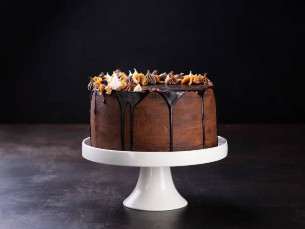 Tasty chocolate drip cake with melting chocolate on a dark background. Copyspace.