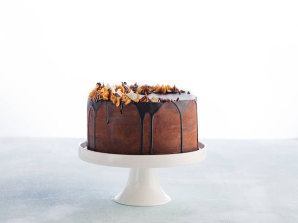 istock Chocolate drip cake with melting chocolate and peanut for a birthday or celebration on light background with copy space. 1155469924