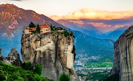 Panoramic view of Meteora mountain and religios monastery of Greece illuminated in sunset light