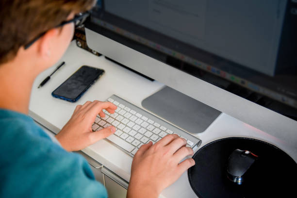 istock Side View Of Teenage Boy Using Computer At Home 1155472918