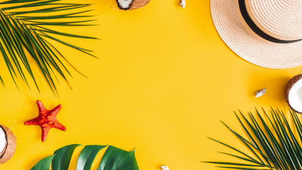 istock Summer composition. Tropical palm leaves, hat, coconut on yellow background. Summer concept. Flat lay, top view, copy space 1155473366