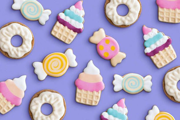 Cookies variety pattern on a pastel background. Various cookie shapes (cupcake, candy, donut). Top view. stock photo
