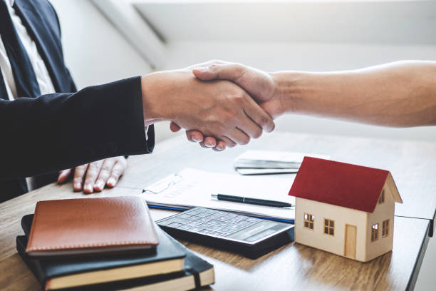 istock Midsection Of Agent Giving Handshake To Customer In Office 1155475842