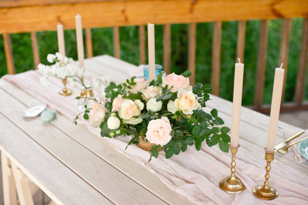 istock Decorated table for dinner for two person, with plates knife, fork, cheese, wine, wine glasses and flowers in a copper vase 1155481409