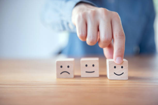 istock Close up customer hand choose smiley face on wood cube, Service rating, satisfaction concept. 1155483968