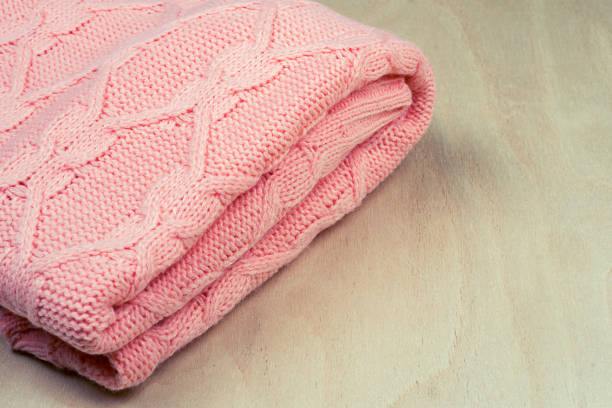 istock Pink knitted material on wooden background with space for text 1155485959