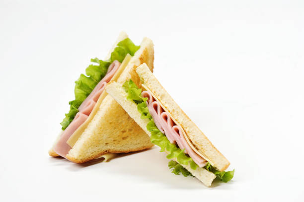 Two triangular sandwiches with cheese and ham. The sandwich is made from slices of fried white bread.  White background.