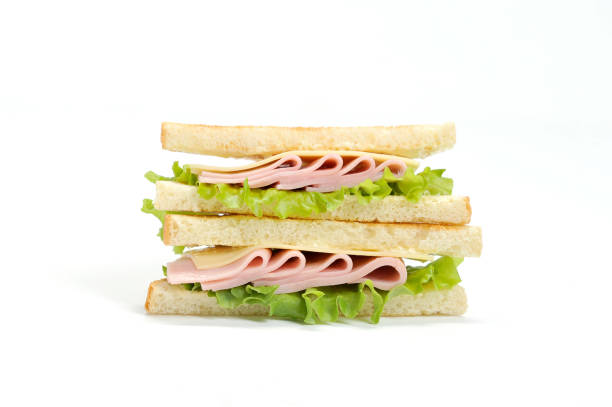 istock A triangular shape sandwich on a white background. The filling of the sandwich consists of lettuce, ham, cheese and fresh vegetables. 1155487480