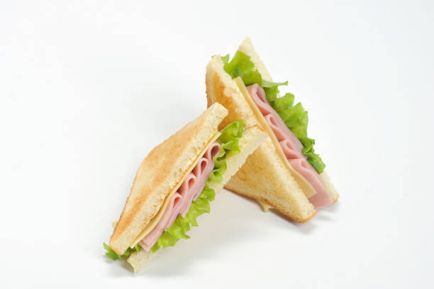 istock Two triangular sandwiches with cheese and ham. The sandwich is made from slices of fried white bread.  White background. 1155487499