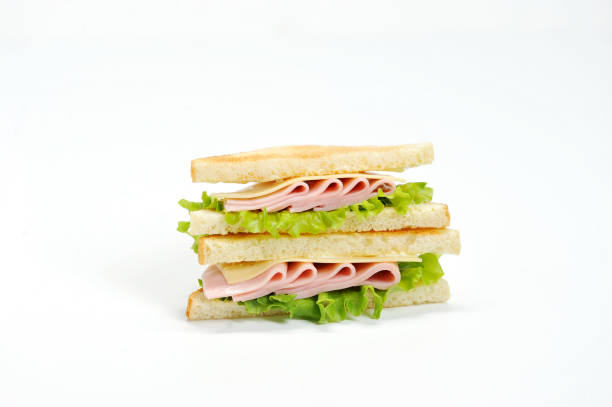 istock A triangular shape sandwich on a white background. The filling of the sandwich consists of lettuce, ham, cheese and fresh vegetables. 1155487528